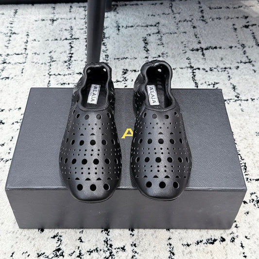 ALAIA 26S FLAT SLIP-ONS IN BLACK CALFSKIN WITH OPENWORK PATTERN