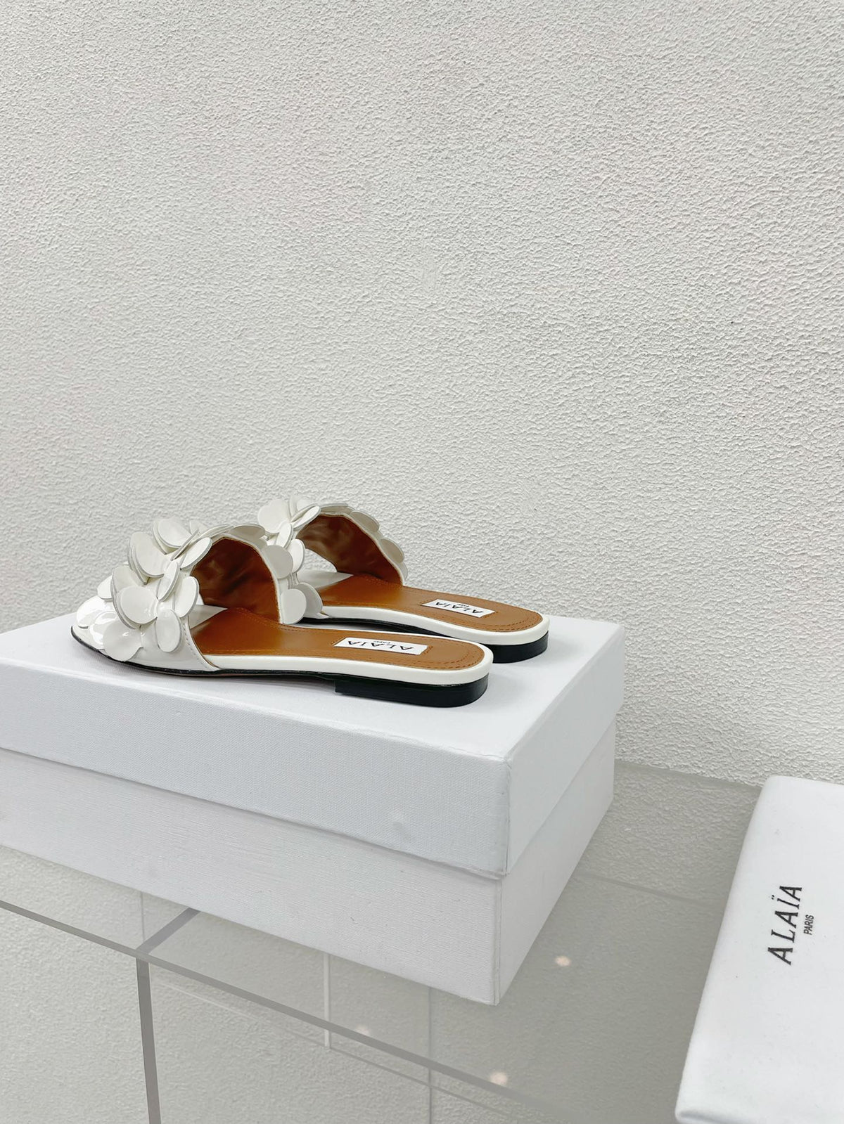ALAIA FLAT MULE IN WHITE GLOSSY LAMBSKIN