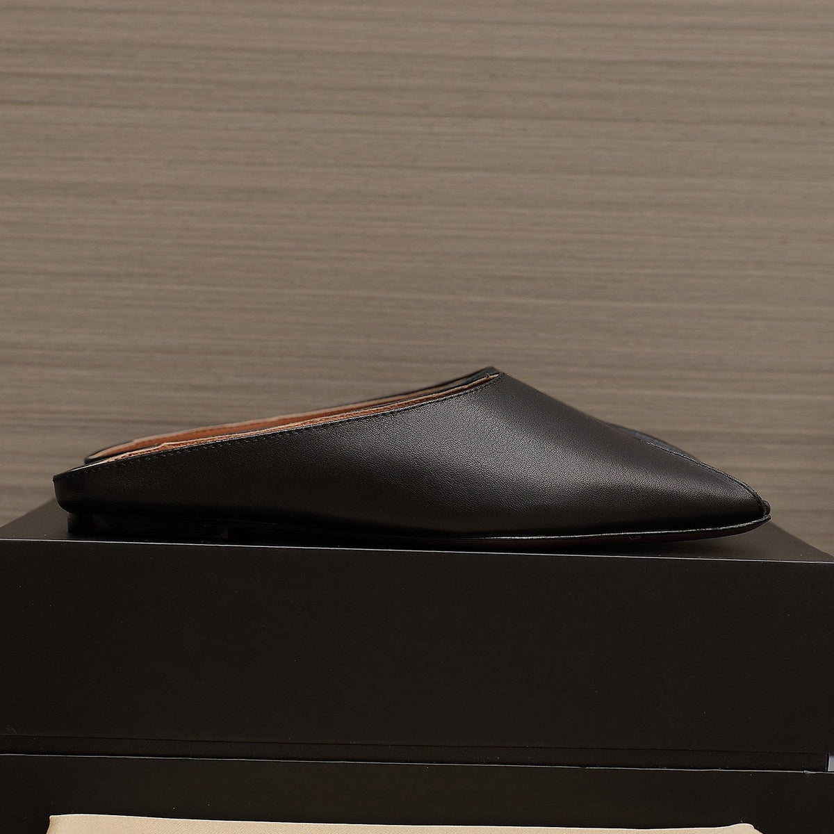 ALAIA FLAT MULE IN BLACK LAMBSKIN